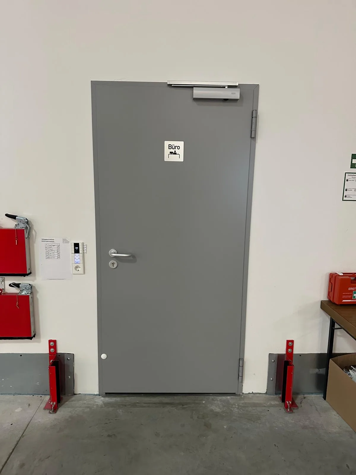 Grau beschichtete Brandschutztür mit Türschließer und elektromagnetischer Feststellanlage in einem Bürogebäude
